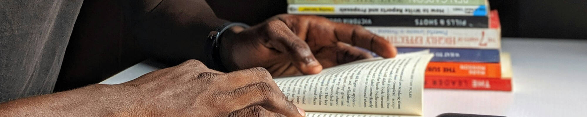 A person's hands holding a book while reading it